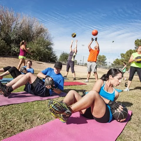 Instructor demonstrating outdoor fitness technique to participants